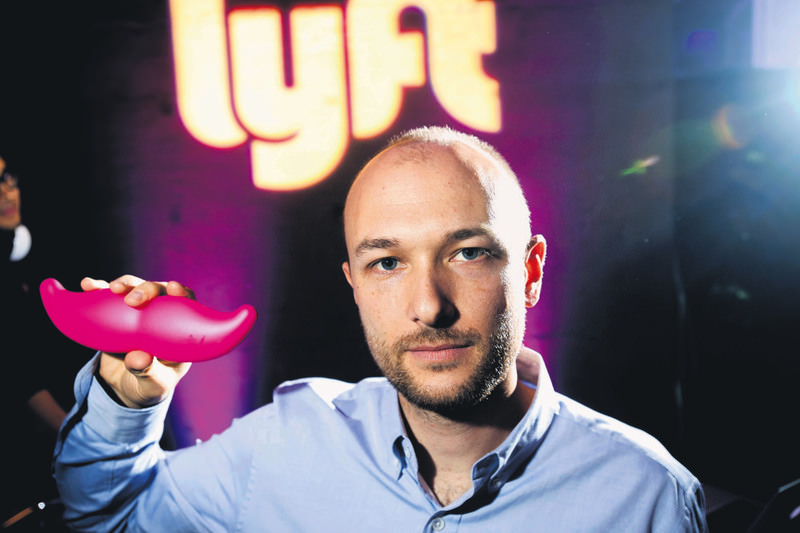 Logan Green, CEO of Lyft, displays his company's ,glowstache, during a launch event in San Francisco.