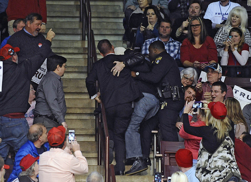 A protester being dragged out while Trump speaks