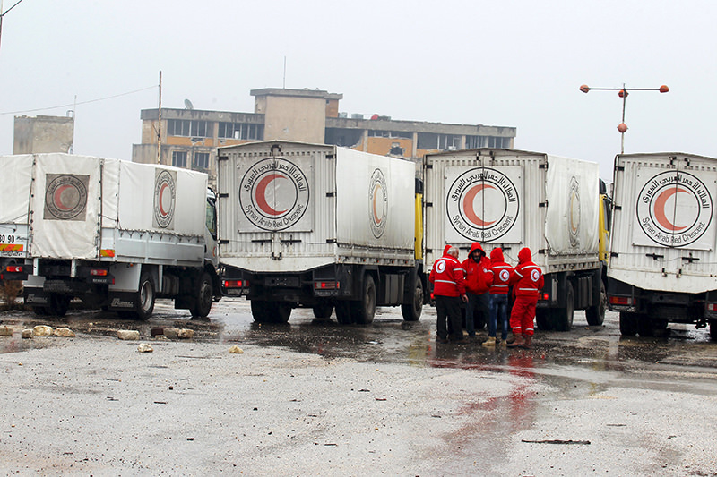 Red Crescent workers stand near their vehicles prior to inspection from rebels before heading to al Foua and Kefraya, in Idlib province, Syria January 11, 2016. (REUTERS Photo)