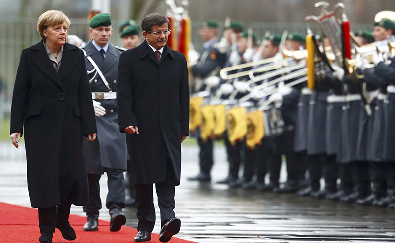 German Chancellor Angela Merkel and Turkish Prime Minister Ahmet Davutoglu (3L) review the Guard of Honour during a welcoming ceremony in Berlin (Reuters Photo)