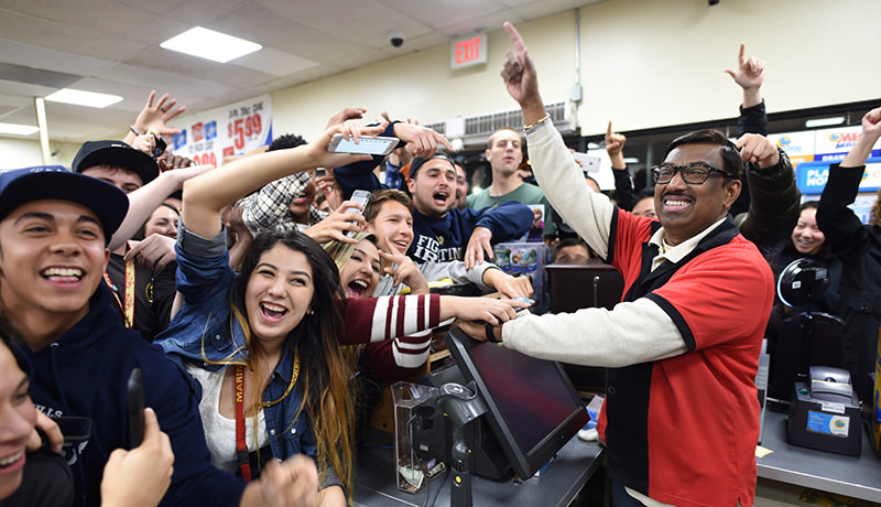 7-Eleven store clerk M. Faroqui celebrates with customers after learning the store sold the only winning Powerball ticket on Wednesday, Jan. 13, 2016 in Chino Hills, Calif (AP Photo)