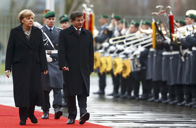 Davutou011flu, Merkel review the Guard of Honour during a welcoming ceremony in Berlin, Jan 12, 2015 (Reuters)