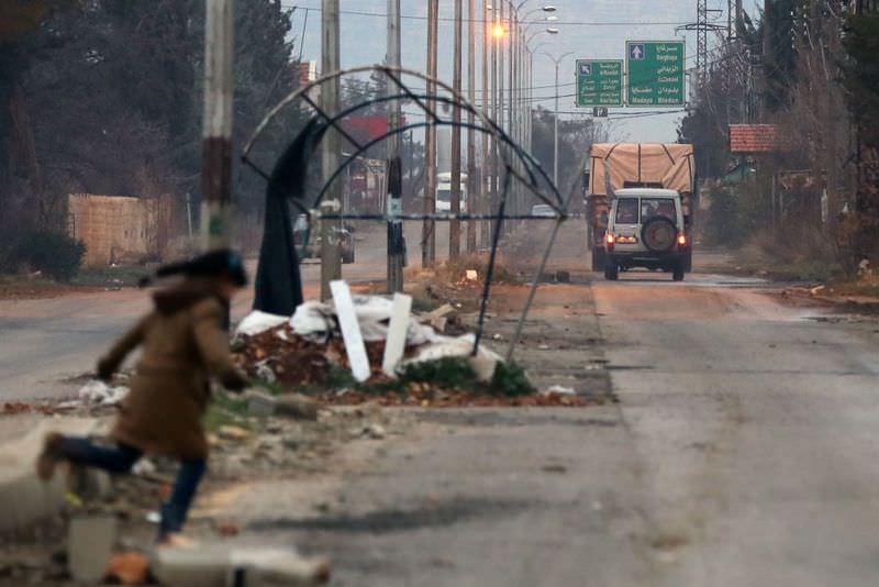A Syrian girl crosses the road on the outskirts of the besieged rebel-held Syrian town of Madaya, as an aid convoy waits to enter the town on Jan. 11.