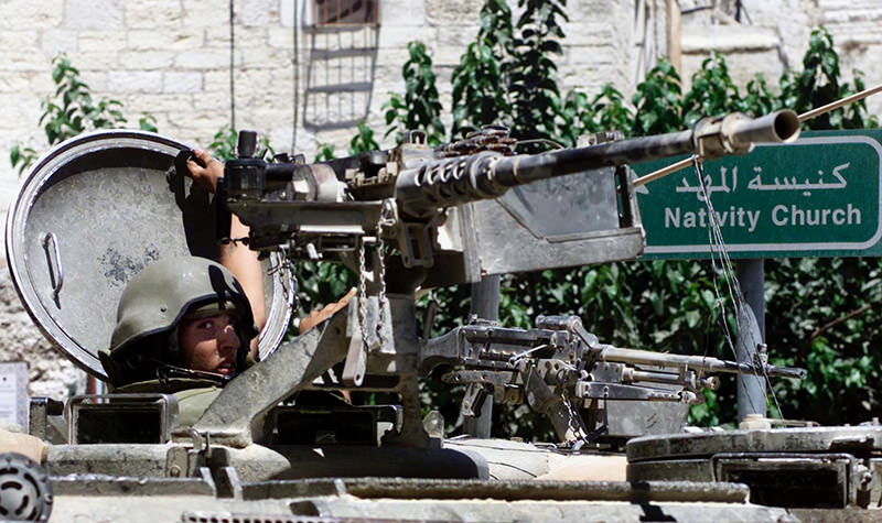 An Israeli soldier close the hatch of his armored personell carrier (APC) during a search in Bethlehem July 8, 2002 near the church of Nativity in Bethlehem (Reuters Photo)
