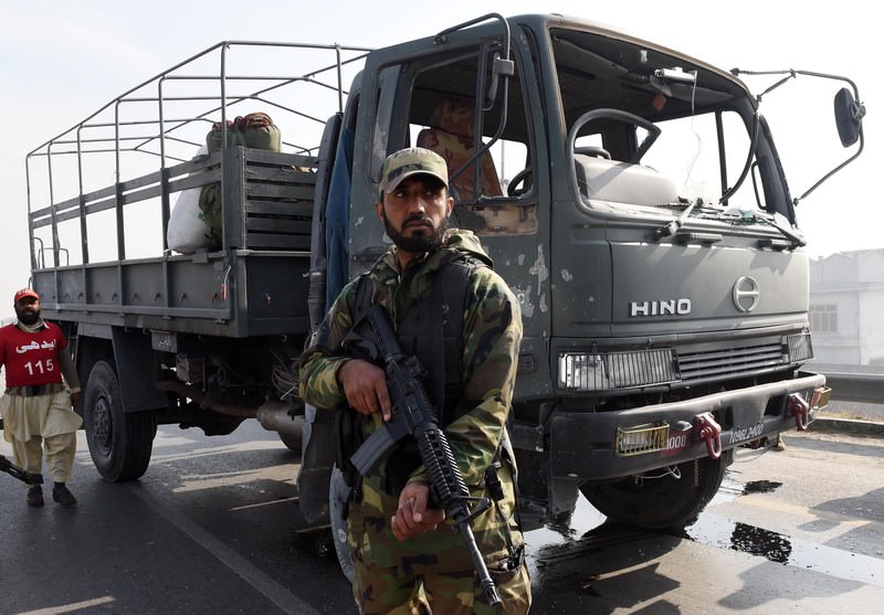 A Pakistan army soldier stands infront of a damaged army vehicle after an Improvised Explosive Device (IED) blast in Peshawar on January 3, 2016 (AFP Photo)