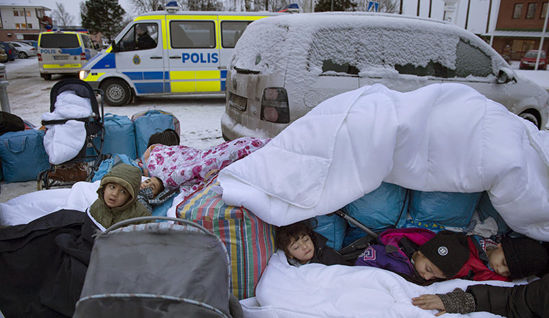  In this Jan. 8, 2016 file photo, migrant children Nor, Saleh and Hajaj Fatema from Syria sleep outside the Swedish Migration Board, in Marsta, Sweden (AP Photo)