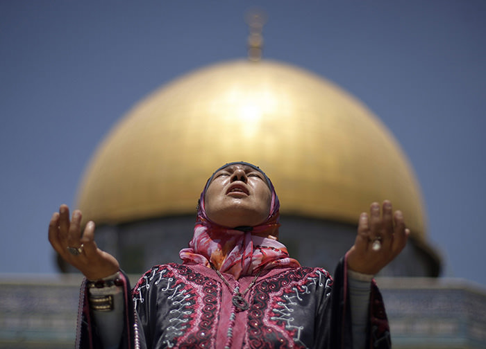 With the Dome of the Rock Mosque seen in the background, a Palestinian female Muslim prays in the Al-Aqsa Mosque compound in Jerusalem's Old City (AP Photo)