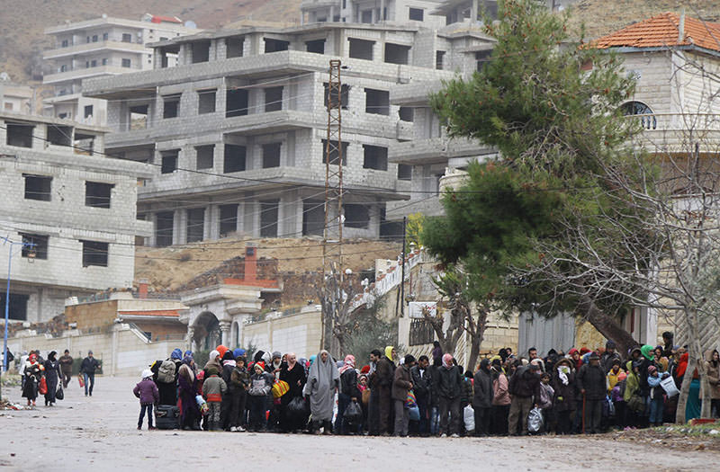 Residents of the besieged rebel-held Syrian town of Madaya wait for a convoy of aid from the Syrian Arab Red Crescent on January 14, 2016 (AFP)