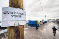 British PM Cameron referred to the refugees living in the terrible conditions at the camp in Calais as a ,bunch of migrants;, however, one of the streets in Calais is named after him, hoping that they can reach the U.K. one day. (AFP Photo)