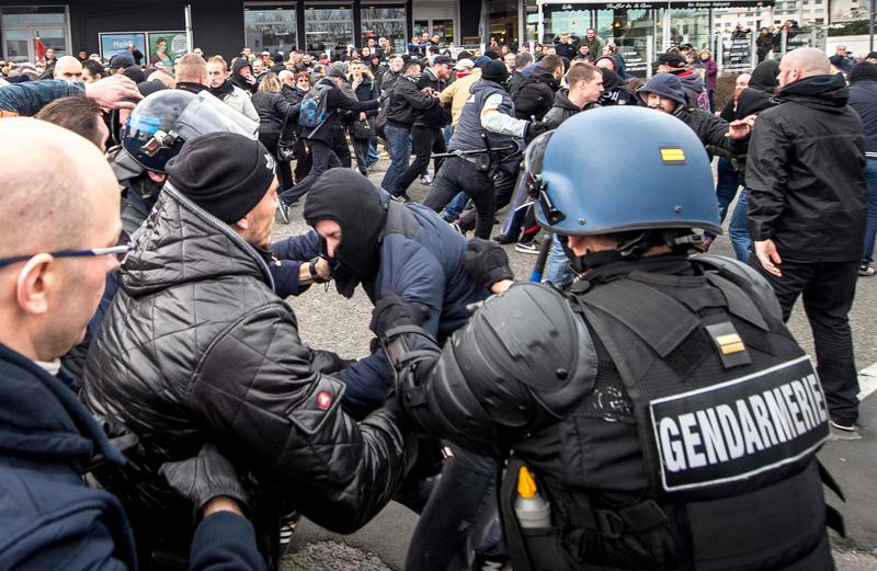 Policemen and anti-riots gendarmes arrest supporters of the Pegida movement during a demonstration in Calais, northern France on February 6, 2016 (AFP Photo)