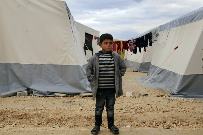 A Syrian boy standing at a temporary refugee camp built by Turkish aid group IHH for displaced Syrians in northern Syria, near the Bab al-Salameh border crossing with Turkey.