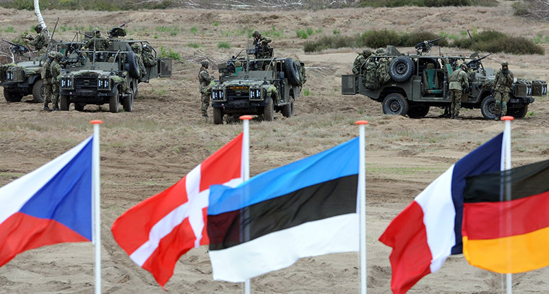n this June 18, 2015,file photo flags wave in front of soldiers who take positions with their army vehicles during the NATO Noble Jump exercise on a training range near Swietoszow Zagan, Poland (AP Photo)