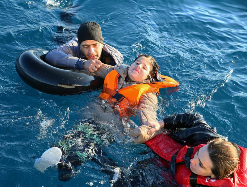 Coast Guard officers help refugees swimming with buoys off the coast of Didim in western Turkey. Their boat capsized en route to Greece, killing four refugees.