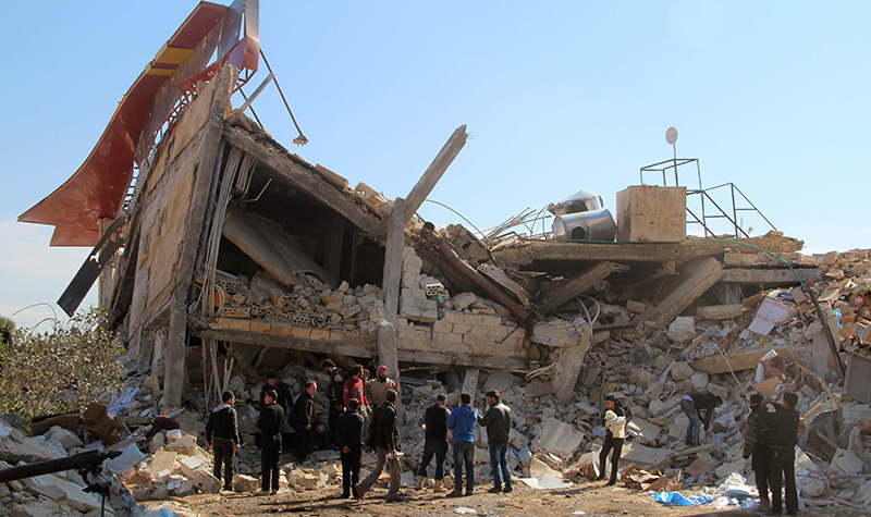 People gather around the rubble of a hospital supported by Doctors Without Borders (MSF) near Maaret al-Numan, in Syria's northern province of Idlib, on February 15, 2016, after the building was hit by suspected Russian air strikes.  (AFP Photo)
