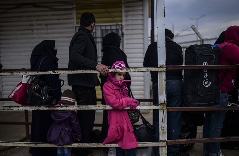 Syrian refugees wait in front of the u00d6ncu00fcpu0131nar crossing gate to go back to Syria, near the town of Kilis, in south-central Turkey, on Feb 11, 2016 (AFP)