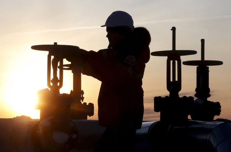 A worker checks the valve of an oil pipe at the Lukoil company owned Imilorskoye oil field outside the West Siberian city of Kogalym, Russia.