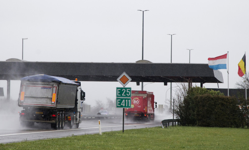 Trucks pass through an open border control point between Belgium and Luxembourg.