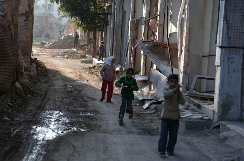 Syrian children playing between buildings destroyed by shelling in the Jobar neighborhood on the eastern outskirts of the capital Damascus, Syria.