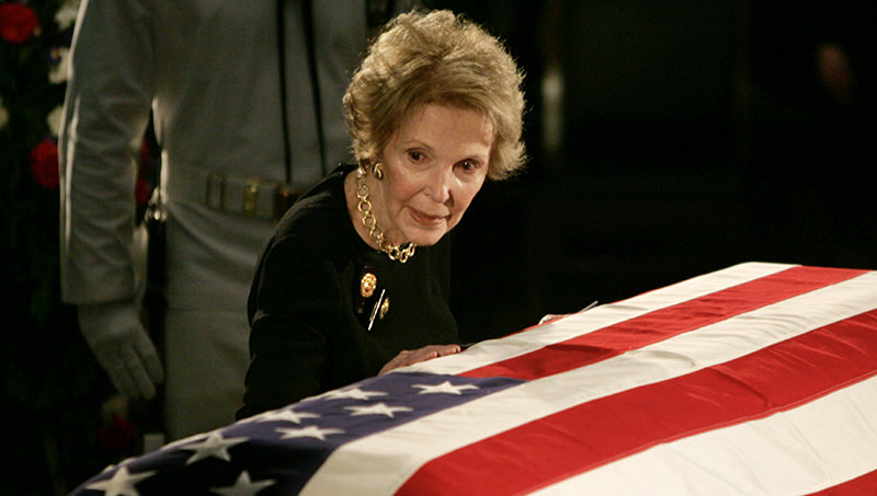 Former U.S. first lady Nancy Reagan touches the casket of her husband, former U.S. President Ronald Reagan as it lies in state in the rotunda of the United States Capitol in Washington in this June 9, 2004 file photo (Reuters Photo)