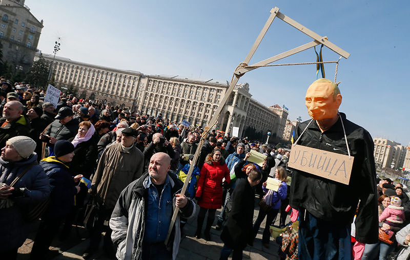Protester holds a symbolic gibbet with an effigy of Putin and plate on it breast reading like 'Killer' during their rally in downtown Kiev, Ukraine, 06 March 2016 (EPA).