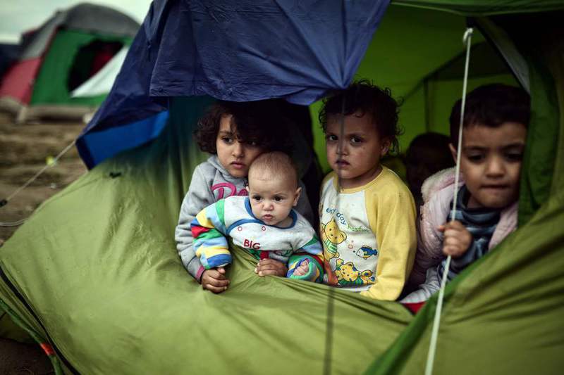 Children sit in a tent in the makeshift camp at the Greek-Macedonian border near the village of Idomeni where thousands of migrants are stranded on March 7.