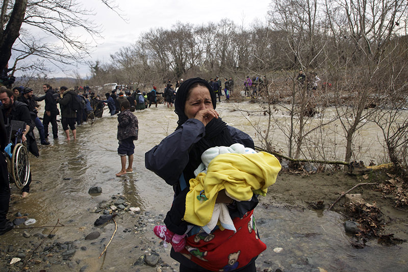 Hundreds of migrants and refugees walked out of an overcrowded camp on the Greek-Macedonian border March 15, 2016. (AP Photo)