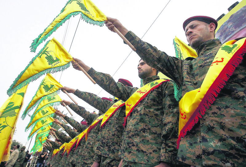 Hezbollah fighters hold the group's flag as they attend a ceremony in South Lebanon.