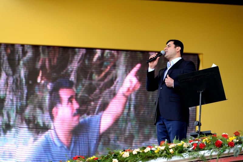 HDP Co-Chair Demirtau015f speaking at a Nevruz gathering in Diyarbaku0131r on Monday with a picture of jailed PKK leader u00d6calan in the background.