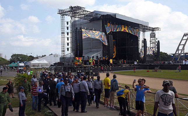 Police officers and fans stand near the stage where Rolling Stones will perform at ,Ciudad Deportiva, in Havana. When the group rock Havana in their first ever Cuban concert, the sound system will blast to as many as a million fans. (AFP Photo)