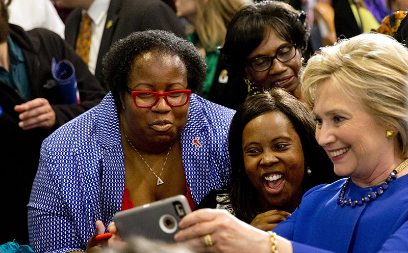In this Feb. 23, 2016 file photo, Democratic presidential candidate Hillary Clinton takes pictures with supporters after a campaign event at the Central Baptist Church in Columbia (AP Photo)