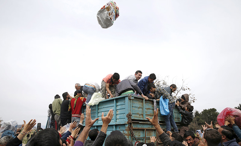  refugees reach out to get humanitarian aid at a makeshift camp at the Greek-Macedonian border near the village of Idomeni, Greece, March 26, 2016 (Reuters Photo)