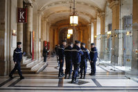 French gendarmes patrol in the Paris hall of Justice, Wednesday, March 30, 2016 while Frenchman Reda Kriket is being questioned by a magistrate. (AP Photo)