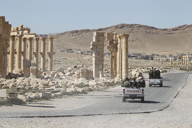 Syrian army soldiers drive past the Arch of Triumph in the historic city of Palmyra, in Homs Governorate, Syria April 1, 2016 (Reuters)