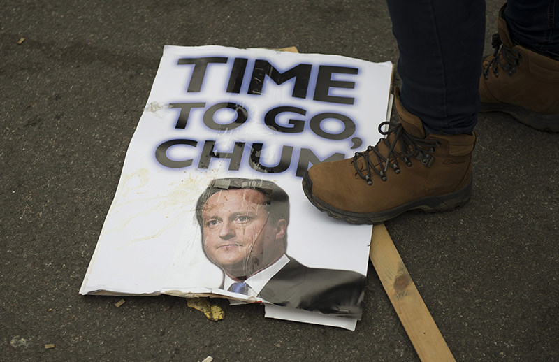 A protester steps on a placard with the picture of British Prime Minister David Cameron during a demonstration calling for Cameron's resignation in Central London. (EPA Photo)