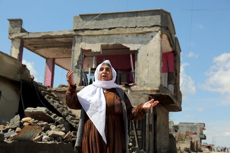 A Kurdish woman reacting as she stands in front of her house, which was damaged by PKK militants, in the southeastern town of Idil, Turkey.