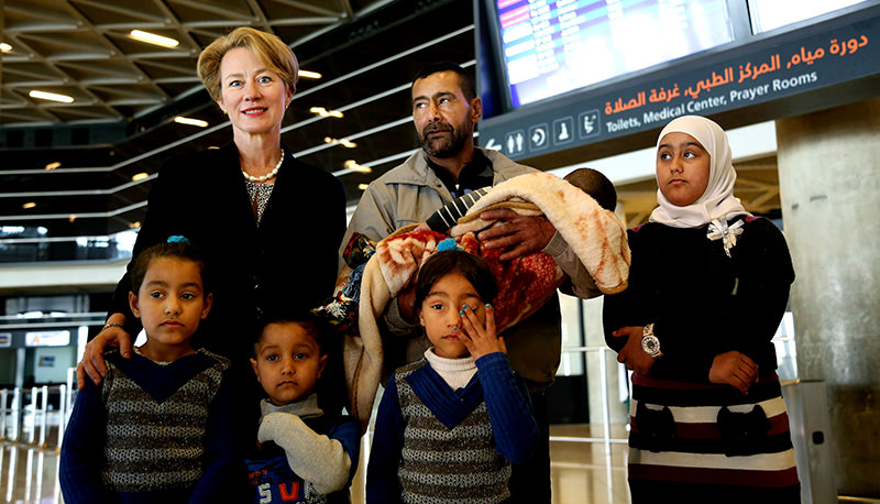 U.S. Ambassador to Jordan Alice Wells, top left, poses for a photo with Syrian refugee Ahmad al-Abboud, top center, and his family at the International Airport of Amman, Jordan, Wednesday, April 6, 2016 (AP Photo)
