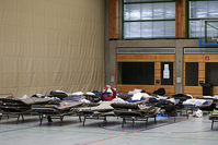 Picture taken on February 19, 2015 shows refugees laying on field beds at the Frankenhalle gym in Neustadt bei Coburg, southern Germany, that was turned into a makeshift shelter for refugees (AFP Photo)