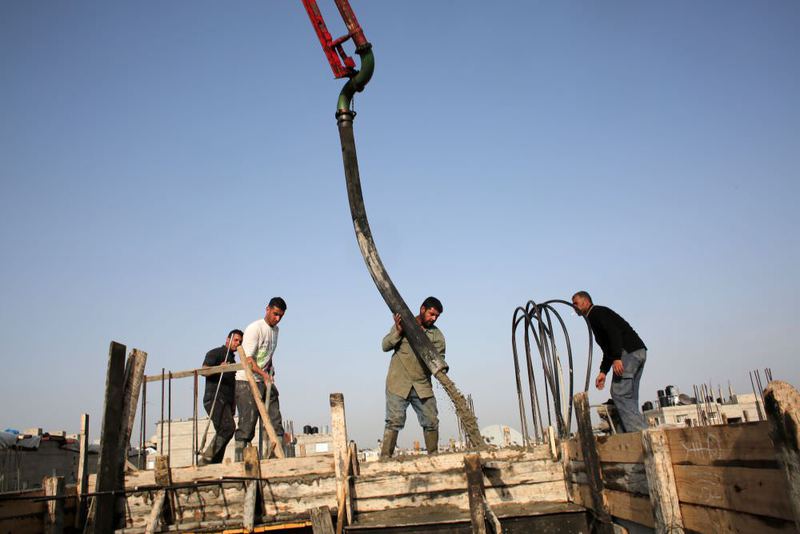 Palestinian workers pour cement on the roof of a building under construction in the southern Gaza Strip town of Rafah. Israel announced it had stopped private imports of cement to the Hamas-run Palestinian enclave.