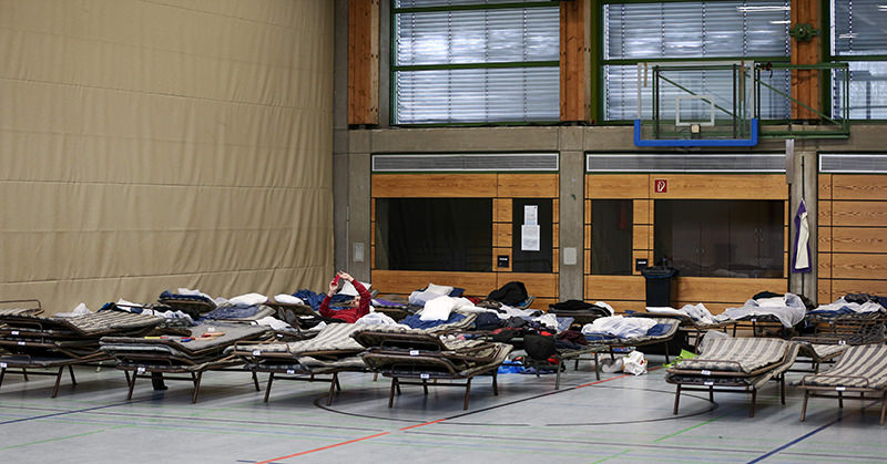Picture taken on February 19, 2015 shows refugees laying on field beds at the Frankenhalle gym in Neustadt bei Coburg, southern Germany, that was turned into a makeshift shelter for refugees (AFP Photo)