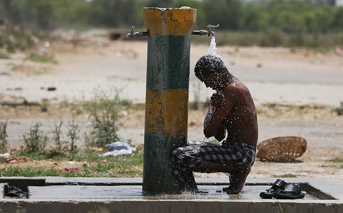  An Indian laborer cools off under a water tap on a hot afternoon in Amritsar, India, 26 May 2015 (EPA Photo)