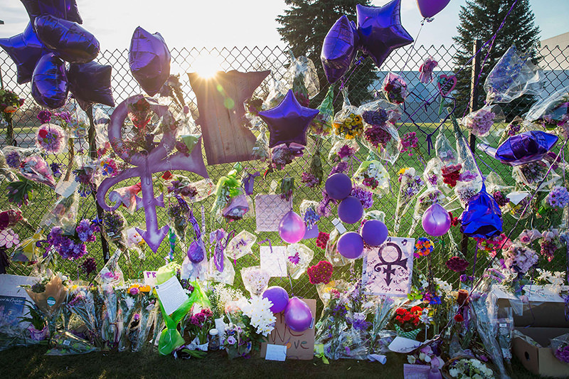 Mementos left by fans are attached to the fence which surrounds Paisley Park, the home and studio of Prince, on April 23, 2016. (AFP Photo)