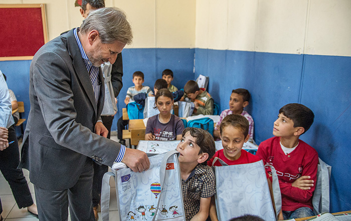 EU Commissioner Johannes Hahn (Center) with refugee children (AA Photo)