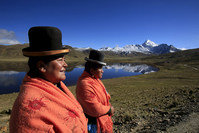 Aymara indigenous women Lidia Huayllas, 48, (L) and Dora Magueno, 50, stand near Milluni lake, with the Huayna Potosi mountain in the background. (REUTERS Photo)
