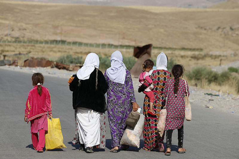 Archive photo: Women, children, fleeing the violence in the Iraqi town of Sinjar, walk to a refugee camp after they re-entered Iraq from Syria (Reuters)