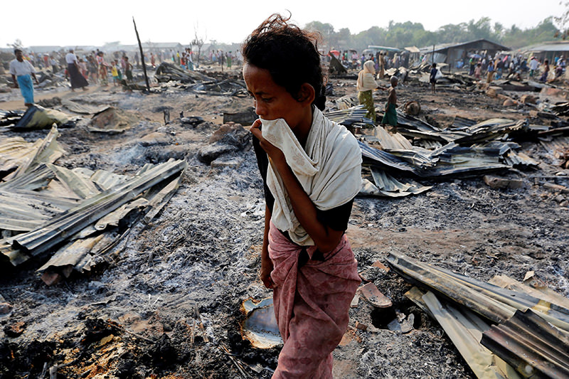 A woman walks among debris after fire destroyed shelters at a camp for internally displaced Rohingya Muslims in the western Rakhine State near Sittwe. (REUTERS Photo)