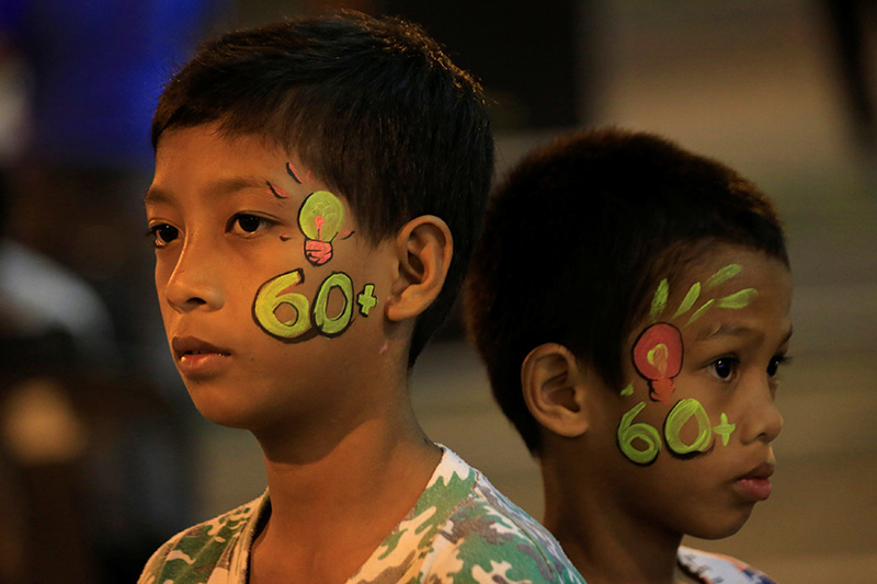 Boys with a painted number 60 on their faces, representing the 60 minutes of Earth Hour, are seen during Earth Hour outside a mall in Bacoor, Cavite city, south of Manila, Philippines March 24, 2018 (Reuters Photo)