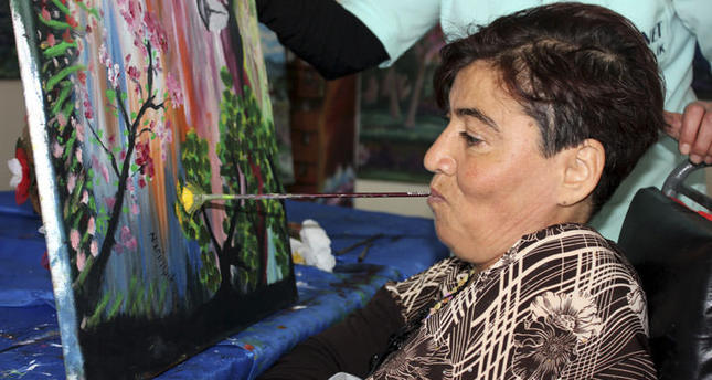 سيدة تركية مصابة بالشلل النصفي تبدع لوحات فنية