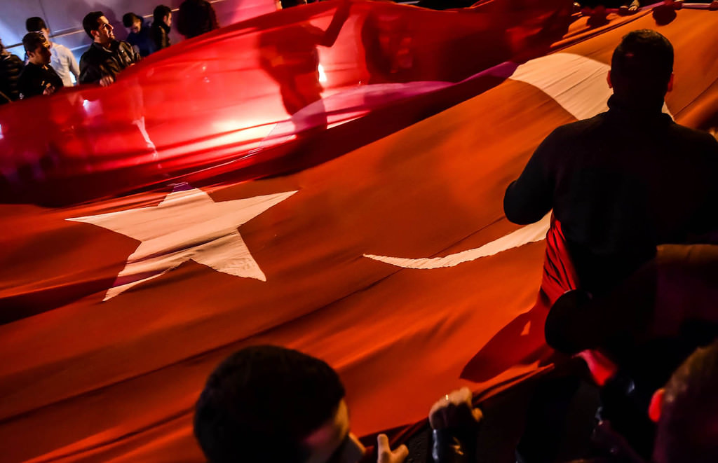 People hold a giant Turkish national flag during a demonstration on December 11, 2016 a day after twin bombings near the home stadium of Besiktas football club. (AFP Photo)