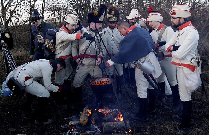 Historical re-enactment enthusiasts dressed as soldiers cook ahead of a re-enactment of battle of Austerlitz. (Reuters Photo)