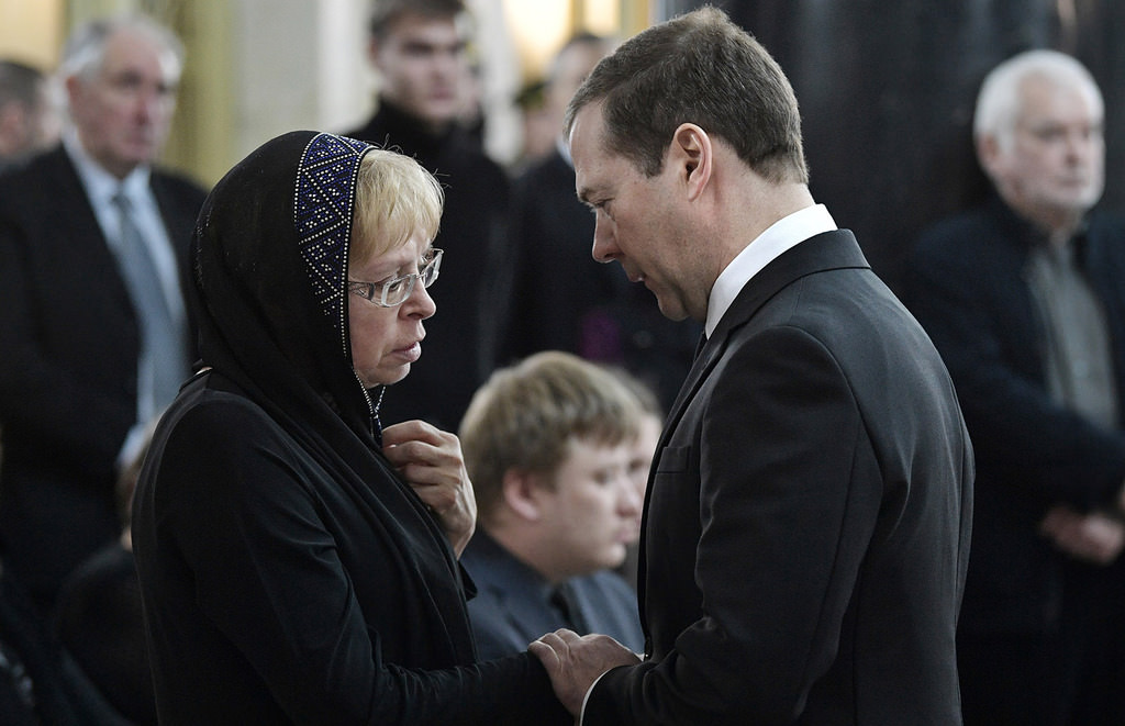 Russian Prime Minister Dmitry Medvedev (R) offers his condolences to Marina Karlova (C), the widow of killed Russian ambassador to Turkey, Andrey Karlov (EPA Photo)